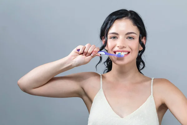 Mujer joven sosteniendo un cepillo de dientes —  Fotos de Stock