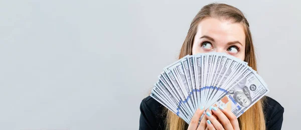 Mujer joven con una pila de dinero en efectivo USD — Foto de Stock