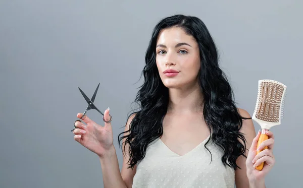 Femme coupant ses cheveux avec des ciseaux — Photo