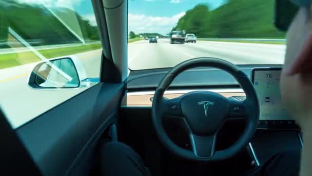 Pessoa dirigindo um novo Tesla Modelo 3 em piloto automático. O modelo 3 é definido para ser o primeiro veículo elétrico do mercado de massa Teslas — Vídeo de Stock