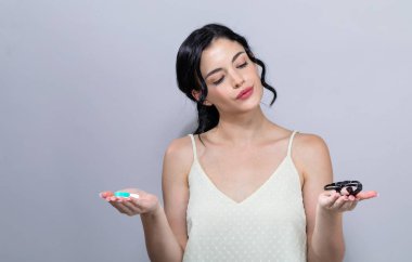 Genç kadın kontakt lensler veya gözlük arasında seçme