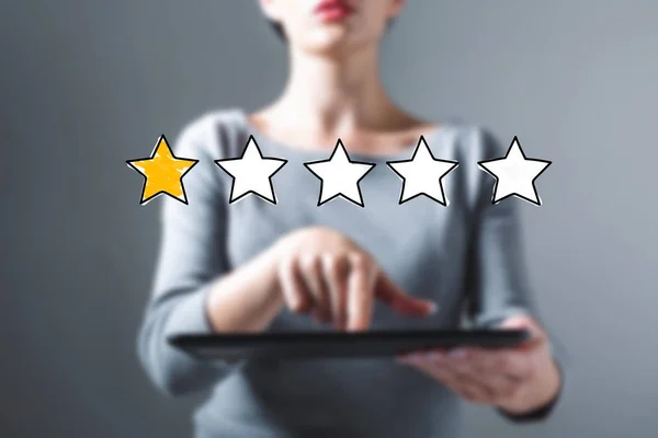 One star rating with woman using a tablet — Stok Foto