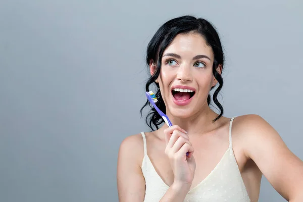 Young woman holding a toothbrush — Stock Photo, Image