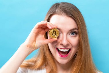 Fiziksel bir bitcoin tutan kadın