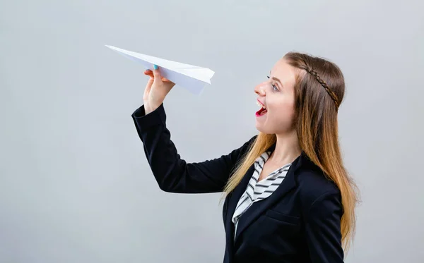 Молодая женщина с бумажным самолетом — стоковое фото