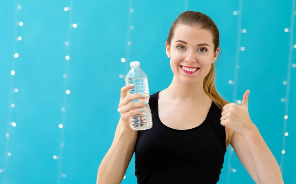 Mujer joven con una botella de agua — Foto de Stock