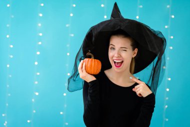 Cadılar Bayramı Balkabağı tutan bir cadı şapka olan kadın