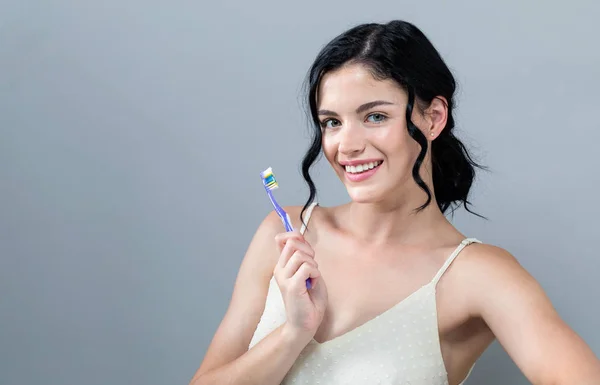 Jonge vrouw met een tandenborstel — Stockfoto