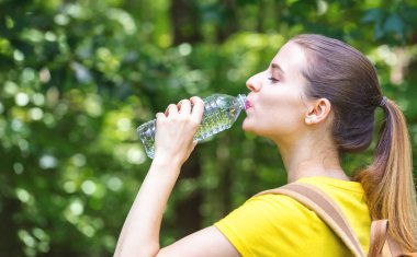 Bir şişe suyu olan genç bir kadın.