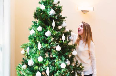 Mutlu genç kadın onun Noel ağacı süsleme