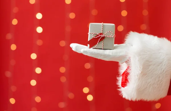 Santa holding a small Christmas gift — Stock Photo, Image