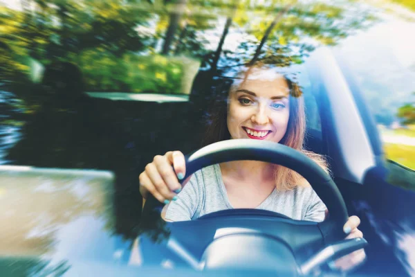 Jovem mulher dirigindo um carro novo — Fotografia de Stock