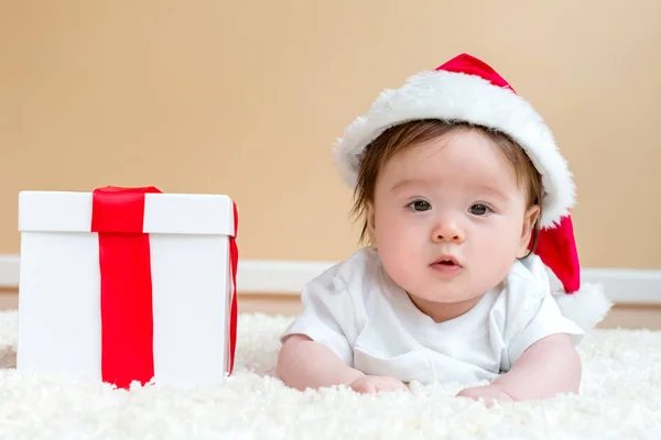 Babyjongen met een kerstcadeau — Stockfoto