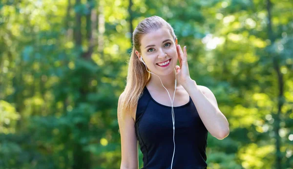 Sportovní mladá žena se sluchátky — Stock fotografie