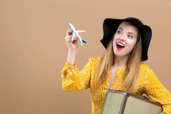 Jovem com uma mala e brinquedo avião viagem tema — Fotografia de Stock