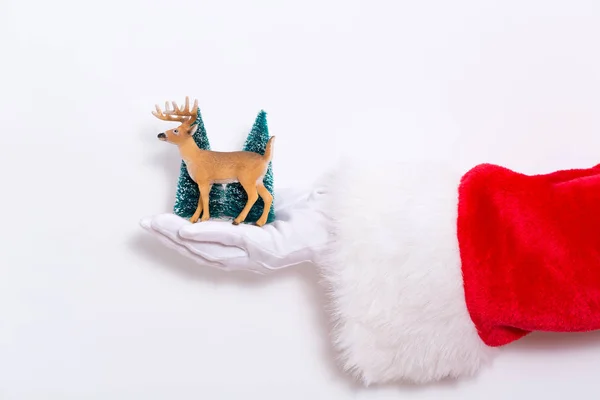 Papai Noel segurando veados de brinquedo e árvores — Fotografia de Stock