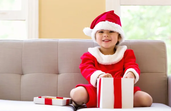Happy toddler girl in a Santa costume with presents — Stock Photo, Image