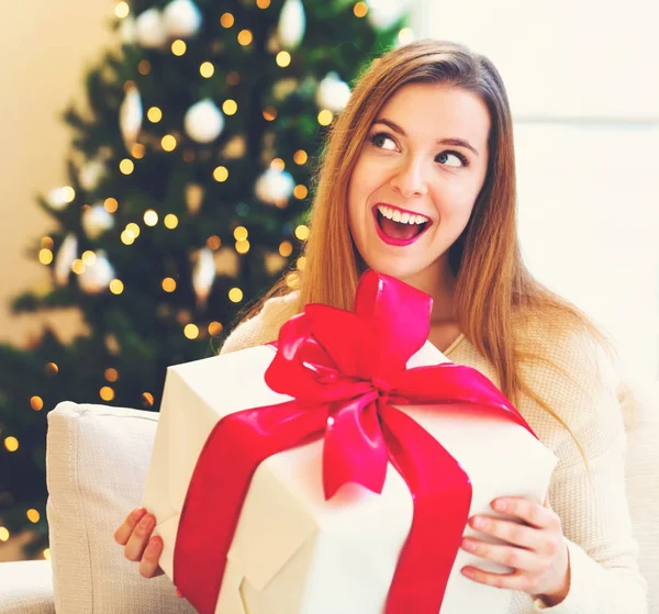 Lycklig kvinna håller en stor presentförpackning — Stockfoto