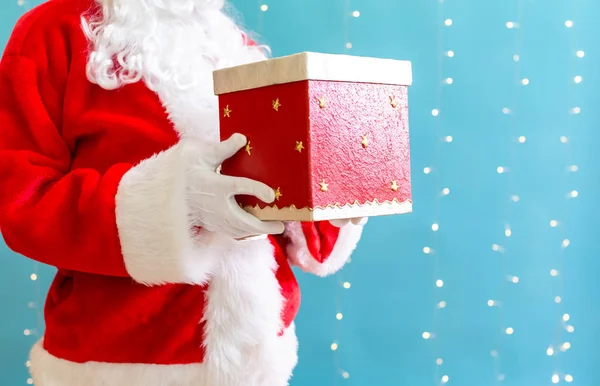 Santa segurando um presente de Natal — Fotografia de Stock