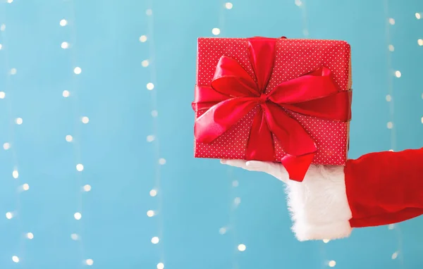 Santa segurando um presente de Natal — Fotografia de Stock
