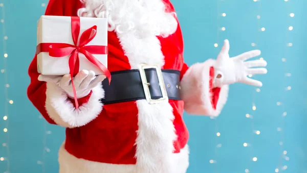 Santa segurando um presente de Natal — Fotografia de Stock