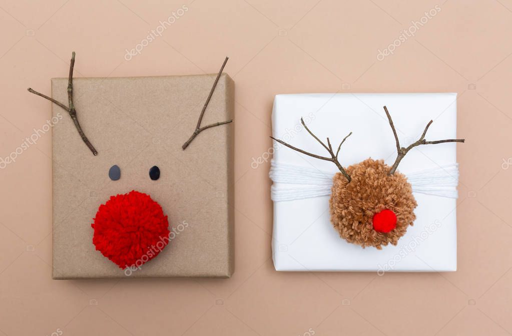 Pompom reindeer gift boxes on brown paper