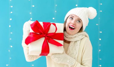 Elinde hediye kutusu olan genç bir kadın.