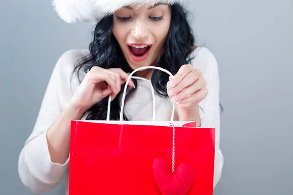 Joyeux jeune femme avec chapeau Santa tenant un sac à provisions — Photo