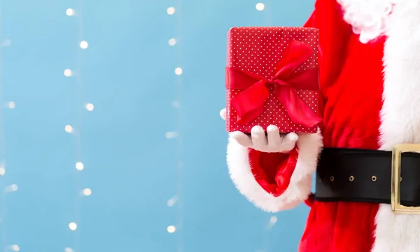 Santa segurando um presente de Natal — Fotografia de Stock