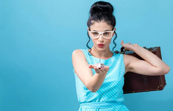 Mujer joven con una maleta y juguete tema de viaje avión —  Fotos de Stock