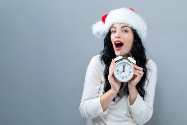 Bir saati yaklaşık 12 gösteren tutan genç kadın