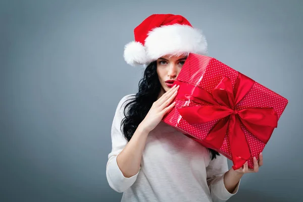 Mujer joven con sombrero de Santa sosteniendo una caja de regalo — Foto de Stock