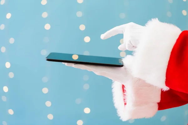 Santa segurando um computador tablet — Fotografia de Stock