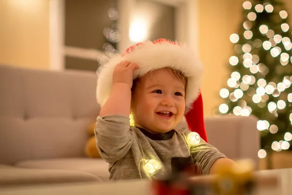 Tout-petit garçon jouant avec un chapeau de Père Noël au moment de Noël — Photo