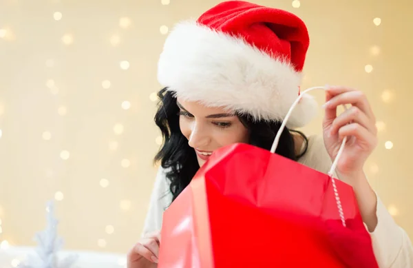 Joyeux jeune femme avec chapeau Santa tenant un sac à provisions — Photo