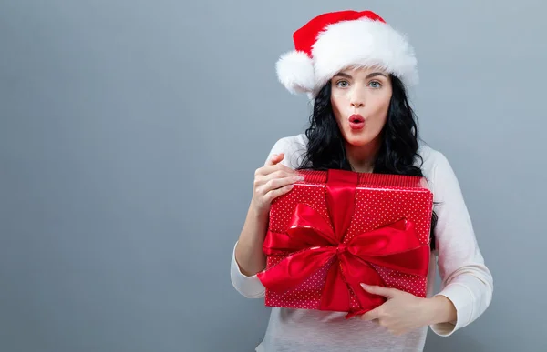 Jonge vrouw met kerstman hoed met een geschenkdoos — Stockfoto