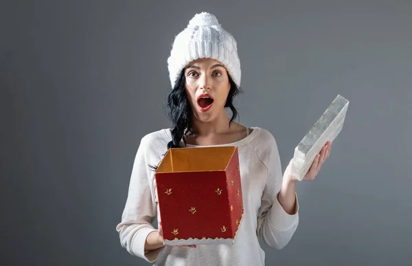 Jovem mulher abrindo uma caixa de presente de Natal — Fotografia de Stock