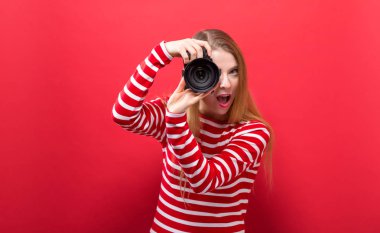 Elinde kamera olan genç bir kadın.
