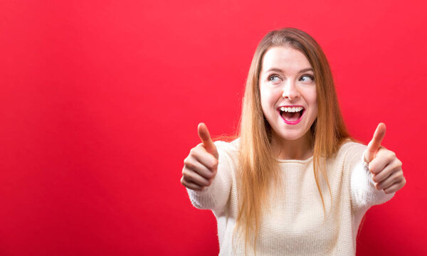Happy young woman giving thumbs up