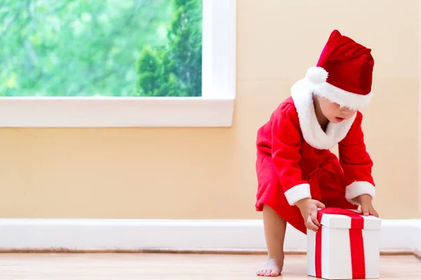 Bonne petite fille dans un costume de Père Noël avec des cadeaux — Photo