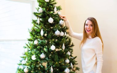 Mutlu genç kadın onun Noel ağacı süsleme