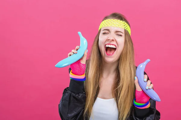 Woman in 1980s fashion holding painted bananas — Stock Photo, Image