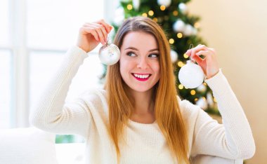 Onun evinde Noel süsler tutan mutlu kadın