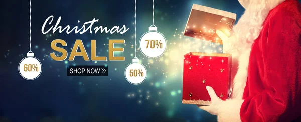 Christmas sale message with Santa opening a gift box — Stock Photo, Image