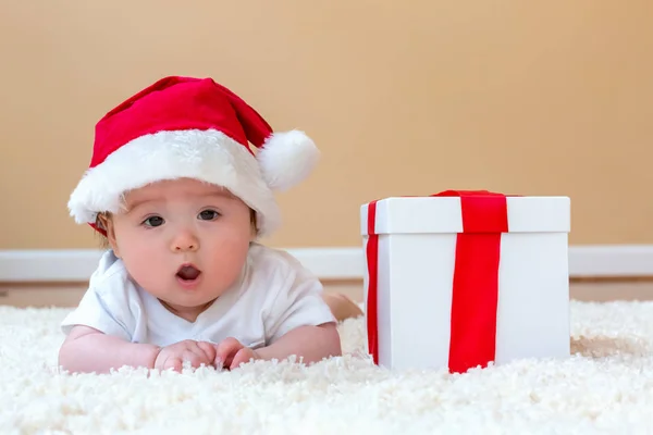 Babyjongen met een kerstcadeau — Stockfoto