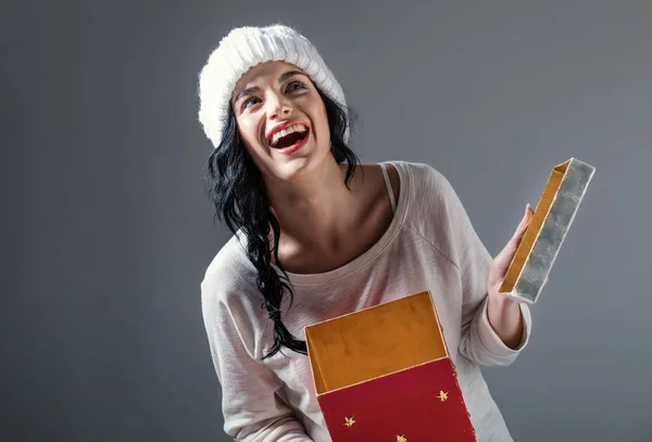 Jovem mulher abrindo uma caixa de presente de Natal — Fotografia de Stock