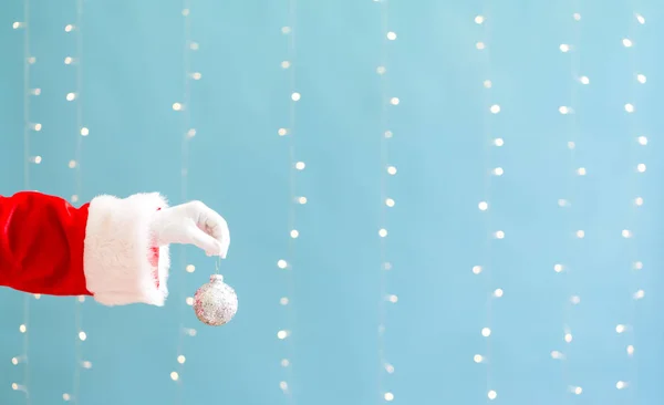 Santa segurando uma bugiganga de Natal — Fotografia de Stock