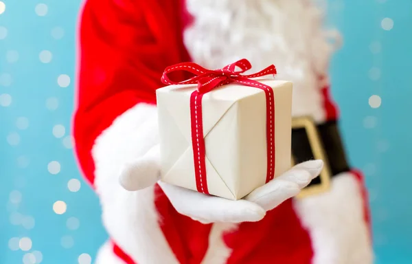 Küçük bir Noel hediyesi tutan Santa — Stok fotoğraf
