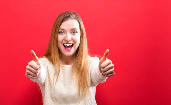 Happy young woman giving thumbs up