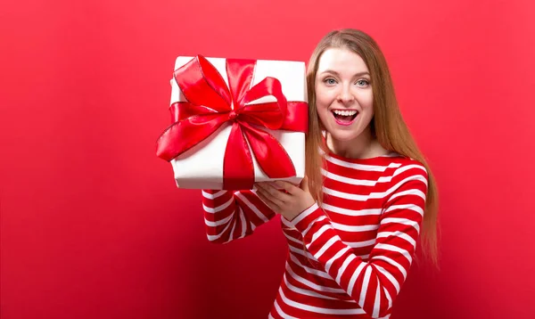 Joyeux jeune femme tenant une boîte cadeau — Photo